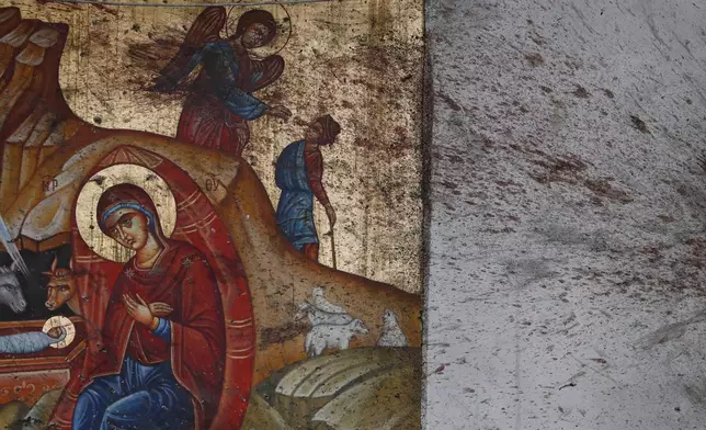 FILE - Blood stains a religious icon of the Virgin Mary and child inside the Mar Elias Greek Orthodox Church in Dweil'a on the outskirts of Damascus, Syria, June 23, 2025, during a memorial service, a day after a suicide bombing. (AP Photo/Omar Sanadiki, File)