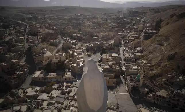 FILE - A statue of the Virgin Mary stands on the top of a cliff with a view of the houses of Maaloula, a village where Aramaic is still spoken, located some 60 km northern Damascus, Syria, Dec. 25, 2024. (AP Photo/Leo Correa, File)