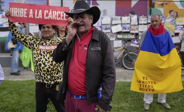 Opponents of former President Alvaro Uribe gather outside the court where a verdict is expected in his trial for witness tampering in Bogota, Colombia, Monday, July 28, 2025. (AP Photo/Fernando Vergara)