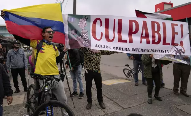 Opponents of former President Alvaro Uribe display a sign reading in Spanish "Guilty" outside the court where a verdict is expected in his trial for witness tampering in Bogota, Colombia, Monday, July 28, 2025. (AP Photo/Fernando Vergara)