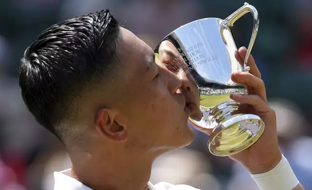 Tokito Oda of Japan kisses the trophy after winning the men's wheelchair singles final match against and Alfie Hewett of Britain at the Wimbledon Tennis Championships in London, Sunday, July 13, 2025.(AP Photo/Joanna Chan)