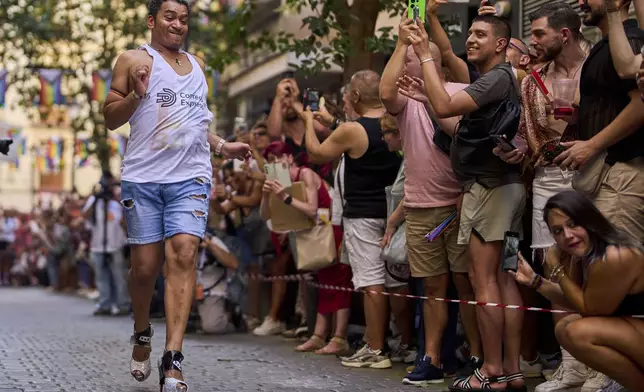 A participant wearing shoes with heels of at least 15 centimeters (5.9 inches) competes in the annual high heel race during Madrid's Pride week, in Madrid, Spain, Thursday, July 3, 2025. (AP Photo/Manu Fernandez)