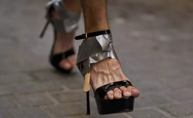 A participant wearing shoes with heels of at least 15 centimeters (5.9 inches) competes in the annual high heel race during Madrid's Pride week, in Madrid, Spain, Thursday, July 3, 2025. (AP Photo/Manu Fernandez)