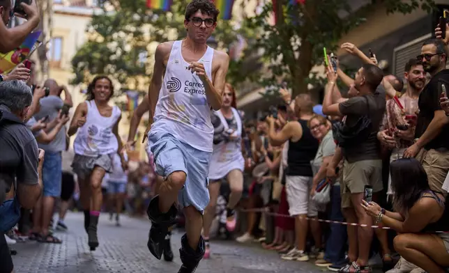 Participants wearing shoes with heels of at least 15 centimeters (5.9 inches) compete in the annual high heel race during Madrid's Pride week, in Madrid, Spain, Thursday, July 3, 2025. (AP Photo/Manu Fernandez)