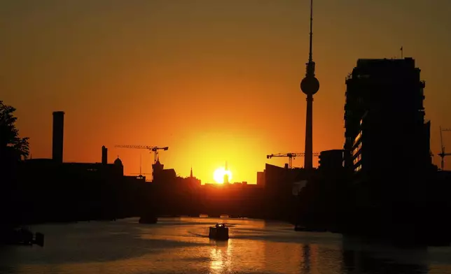 The Television Tower silhouettes in the sunset on a day with hot summer weather in Berlin, Germany, Tuesday, July 1, 2025. (AP Photo/Markus Schreiber)