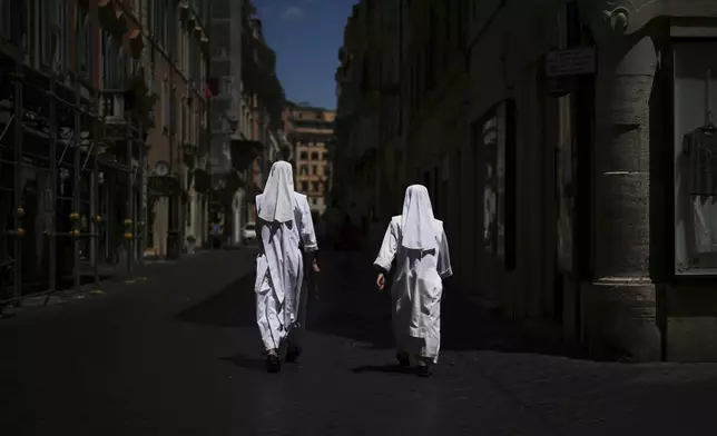 Two nuns walk in a street in downtown Rome, Tuesday, July 1, 2025. (AP Photo/Andrew Medichini)