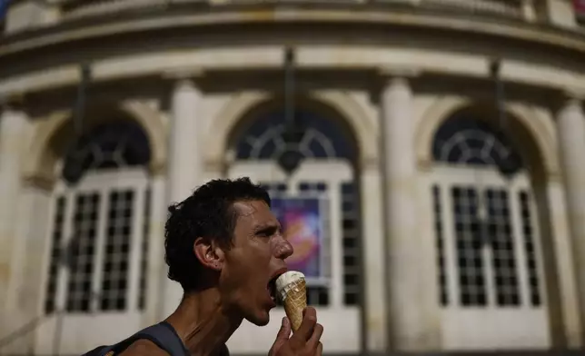 A man eats an ice cream during a heat wave, Tuesday, July 1, 2025 in Rennes, western France. (AP Photo/Jeremias Gonzalez)