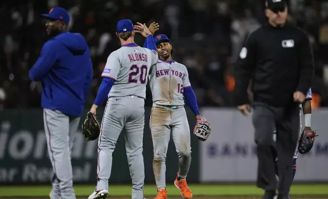 New York Mets shortstop Francisco Lindor (12) and first baseman Pete Alonso (20) celebrate after the team's victory over the San Francisco Giants in a baseball game Friday, July 25, 2025, in San Francisco. (AP Photo/Godofredo A. Vásquez)