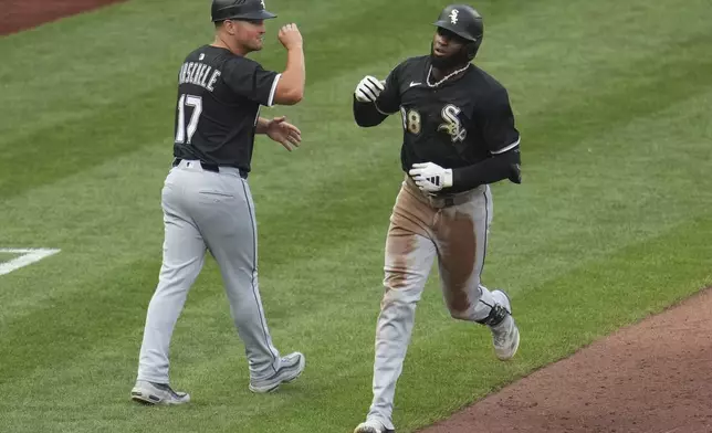 Chicago White Sox's Luis Robert Jr., right, is greeted by third base coach Justin Jirschele (17) as he rounds third after hitting a solo home run off Pittsburgh Pirates pitcher Bailey Falter during the fourth inning of a baseball game in Pittsburgh, Friday, July 18, 2025. (AP Photo/Gene J. Puskar)