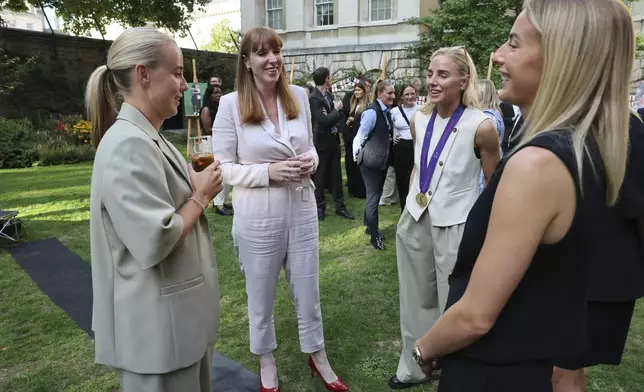 Deputy British Prime Minister Angela Rayner, second left, speaks with England's Beth Mead, left, Alex Greenwood, and Chloe Kelly, right, as they attend a special reception, to celebrate their victory in the Women's Euro 2025 final, at Downing Street in London, Monday, July 28, 2025. (Richard Pohle/Pool Photo via AP)