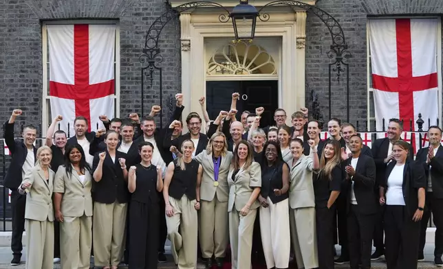 England head coach Sarina Wiegman, center, poses with her staff and England's Football Association president Debbie Hewitt, 2nd left, after leaving a special reception, to celebrate their victory in the Women's Euro 2025 final, at Downing Street in London, Monday, July 28, 2025. (AP Photo/Kirsty Wigglesworth)