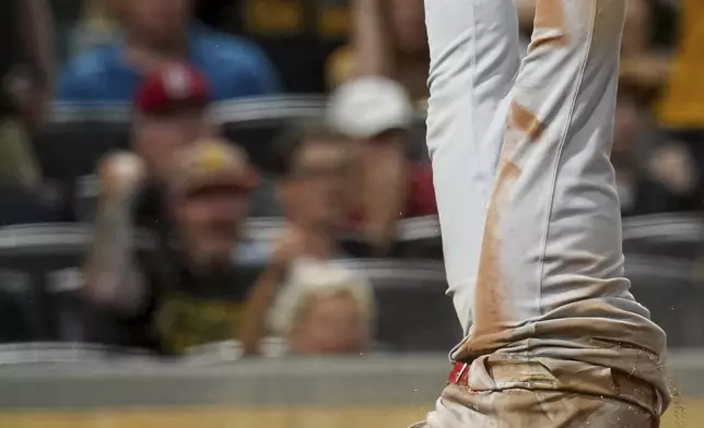 St. Louis Cardinals' Jose Fermin is upended after getting tagged out at home during the ninth inning of a baseball game, Tuesday, July 1, 2025, in Pittsburgh. (AP Photo/Matt Freed)