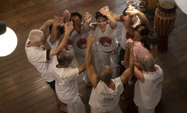 Attendees and staff of the “Parkinson's in the swing” project come together after a capoeira class for Parkinson's patients at the Progress Foundry cultural center in Rio de Janeiro, Tuesday, July 15, 2025. (AP Photo/Bruna Prado)
