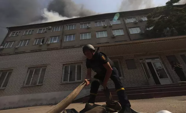 Rescue workers put out a fire of a building destroyed by a Russian drone strike in Zaporizhzhia, Ukraine, on Monday, July 7, 2025. (AP Photo/Kateryna Klochko)