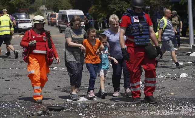 Paramedics help residents evacuate their house that was destroyed by a Russian airstrike in Kharkiv, Ukraine, Monday, July 7, 2025. (AP Photo/Andrii Marienko)