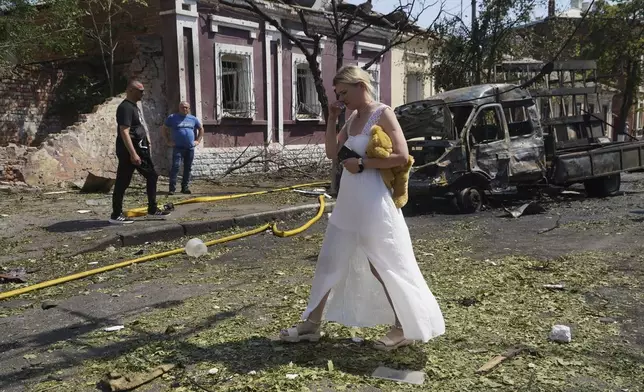A woman reacts as she leaves her home that was destroyed by a Russian airstrike in Kharkiv, Ukraine, Monday, July 7, 2025. (AP Photo/Andrii Marienko)