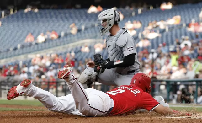 Washington Nationals' Luis García Jr. (2) slides into home plate and beats the tag from Detroit Tigers catcher Dillon Dingler and scores a run on a ball hit by Josh Bell against pitcher Jack Flaherty during the first inning in the second baseball game of a doubleheader in Washington, Wednesday, July 2, 2025. (AP Photo/Terrance Williams)