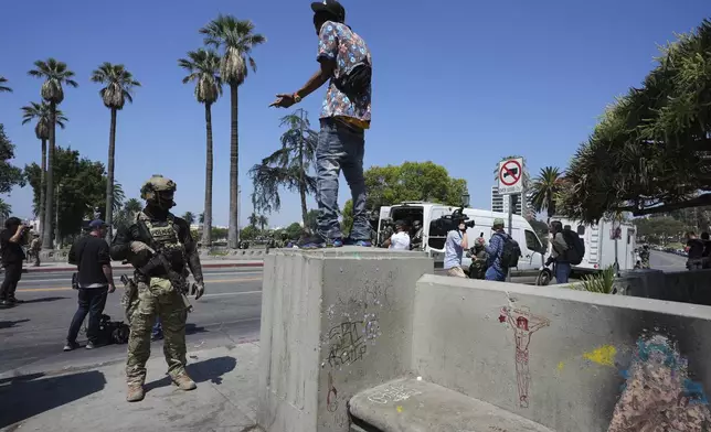 A person confronts a police officer at MacArthur Park Monday, July 7, 2025, in Los Angeles. (AP Photo/Damian Dovarganes)