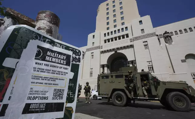 Federal agents stage Monday, July 7, 2025, in Los Angeles. (AP Photo/Damian Dovarganes)
