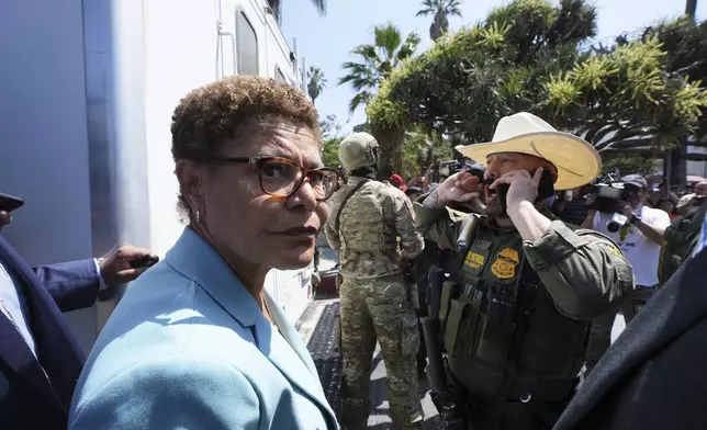 Los Angeles Mayor Karen Bass stands in front of a border patrol federal agent at MacArthur Park Monday, July 7, 2025, in Los Angeles. (AP Photo/Damian Dovarganes)