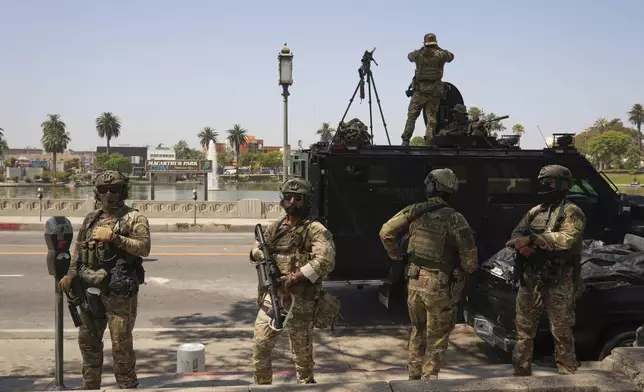 Federal agents stage at MacArthur Park Monday, July 7, 2025, in Los Angeles. (AP Photo/Damian Dovarganes)