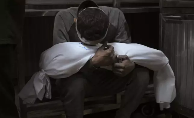 Hossam Azzam holds the body of his child, Amir, who was killed in an Israeli military airstrike on Gaza, at Shifa Hospital in Gaza City Tuesday, July 15, 2025. (AP Photo/Jehad Alshrafi)
