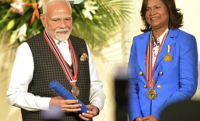 India's Prime Minister Narendra Modi, left, receives the Order of the Republic of Trinidad and Tobago, the nation's highest honor, from Trinidad and Tobago President Carla Kangaloo at presidential residence in Port of Spain, Trinidad and Tobago, Friday, July 4, 2025. (AP Photo/Robert Taylor)