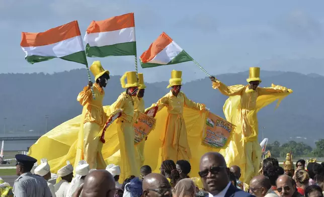 Moko Jumbies wave Indian flags during Indian Prime Minister Narendra Modi's arrival at Piarco International Airport in Piarco, Trinidad and Tobago, Thursday, July 3, 2025. (AP Photo/Jermaine Cruickshank)