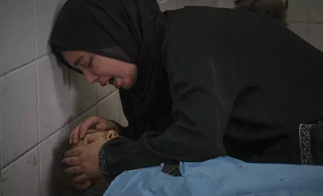 Sara Al-Nouri mourns over the body of her 13-year-old sister, Sama, who was among 10 people, including two women and five children, killed in an Israeli strike while they were waiting to receive nutritional supplements at a Project Hope-run medical clinic in Deir al-Balah, Gaza Strip, Thursday, July 10, 2025. (AP Photo/Abdel Kareem Hana)