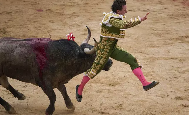 Spanish bullfighter Rafaelillo is gored during a bullfight at the San FermÌn festival in Pamplona, northern Spain, Saturday, July 12, 2025. (AP Photo/Miguel Oses)