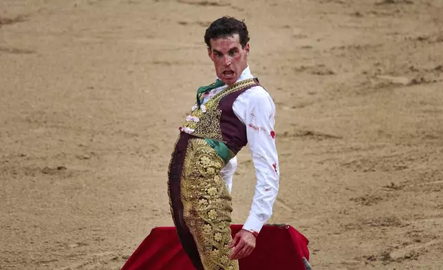 Spanish bullfighter Fernando Adrián performs during a bullfight at the San Fermín festival in Pamplona, northern Spain, Sunday, July 13, 2025. (AP Photo/Miguel Oses)