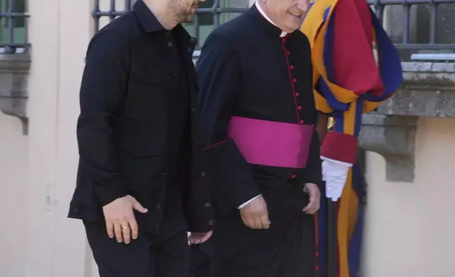 Ukraine President Volodymyr Zelenskyy, left, walks with Father Lorenzo Sapienza past Swiss guards ahead of his meeting with Pope Leo XIV in Castel Gandolfo, Italy, Wednesday, July 9, 2025. (AP Photo/Gregorio Borgia)
