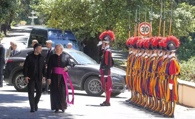 Ukraine President Volodymyr Zelenskyy, left, walks with Father Lorenzo Sapienza past Swiss guards ahead of his meeting with Pope Leo XIV in Castel Gandolfo, Italy, Wednesday, July 9, 2025. (AP Photo/Gregorio Borgia)