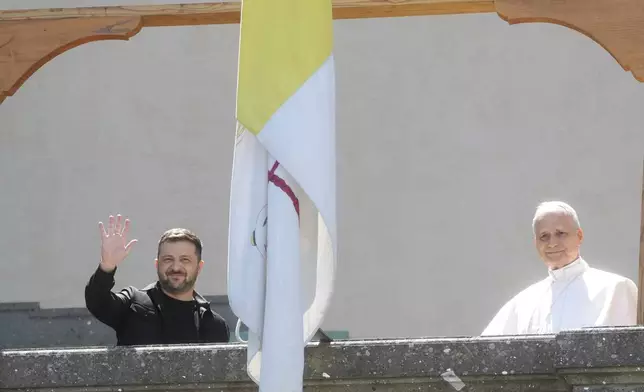 Ukraine President Volodymyr Zelenskyy, left, and Pope Leo XIV wave to journalists during their meeting in Castel Gandolfo, Italy, Wednesday, July 9, 2025. (AP Photo/Gregorio Borgia)