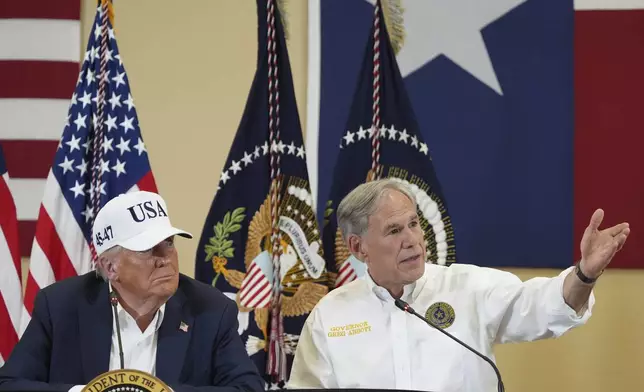 Texas Gov. Greg Abbott speaks as President Donald Trump listens during a roundtable discussion with first responders and local officials at Hill Country Youth Event Center in Kerrville, Texas, during a tour to observe flood damage, Friday, July 11, 2025. (AP Photo/Jacquelyn Martin)