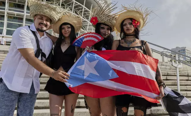 Bad Bunny fans pose for a photo before attending the first show of his 30-date concert residency at the Coliseo de Puerto Rico Jose Miguel Agrelot in San Juan, Puerto Rico, Friday, July 11, 2025. (AP Photo/Alejandro Granadillo)