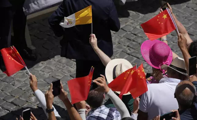 Faithful cheer as they hold China and Vatican flags during the noon Angelus prayer with Pope Leon XIV, in the square in front of the Apostolic Palace for in Castel Gandolfo, Italy, Sunday, July 20, 2025. (AP Photo/Gregorio Borgia)