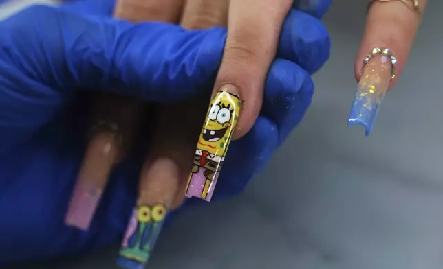 Manicurist Marisel Darias Valdes works on a client's nails in Havana, Cuba, Tuesday, June 24, 2025. (AP Photo/Ramon Espinosa)