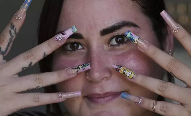 Mariam Camila Sosa strikes a pose to show off her freshly decorated fingernails, at a home-run nail salon in Havana, Cuba, Tuesday, June 24, 2025. (AP Photo/Ramon Espinosa)