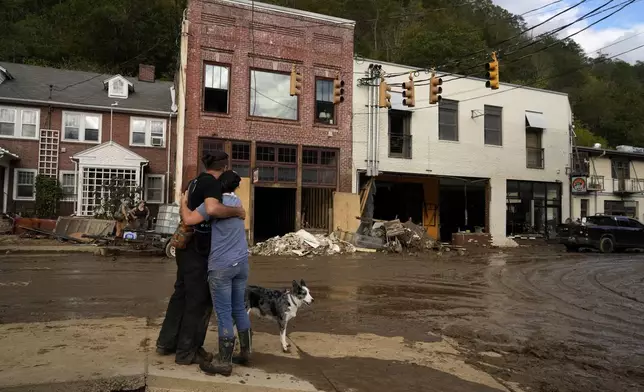 FILE - Resident Anne Schneider, right, hugs her friend, Eddy Sampson, as they survey damage caused by Hurricane Helene on Oct. 1, 2024, in Marshall, N.C. (AP Photo/Jeff Roberson, File)