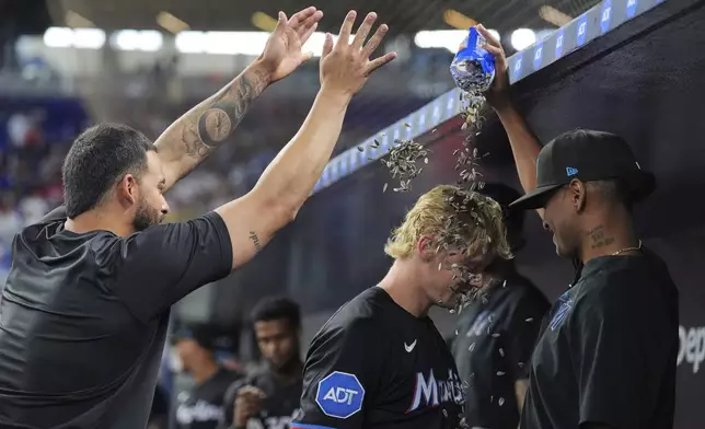 Miami Marlins' Kyle Stowers, center, is celebrated by teammates after hitting a two-run homer in the first inning of a baseball game against the Kansas City Royals, Friday, July 18, 2025, in Miami. (AP Photo/Rebecca Blackwell)