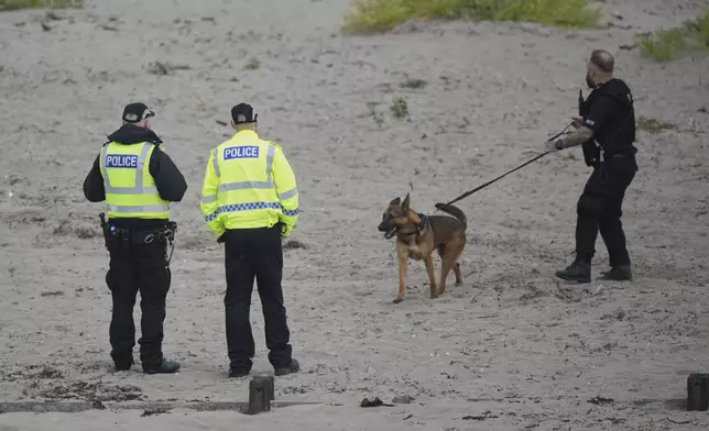 A police dog handler walks his dog on the beach to help with security at the Trump Turnberry golf course in Turnberry, Scotland, Friday, July 25, 2025, ahead of President Trump's visit Scotland. (AP Photo/Alastair Grant)