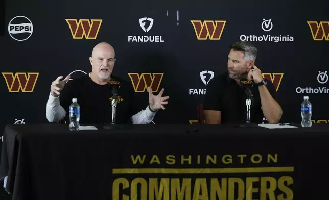 Washington Commanders head coach Dan Quinn, left, speaks as general manager Adam Peters, right, looks on during a news conference at the NFL football team's training camp in Ashburn, Va., Tuesday, July 22, 2025. (AP Photo/Luis M. Alvarez)