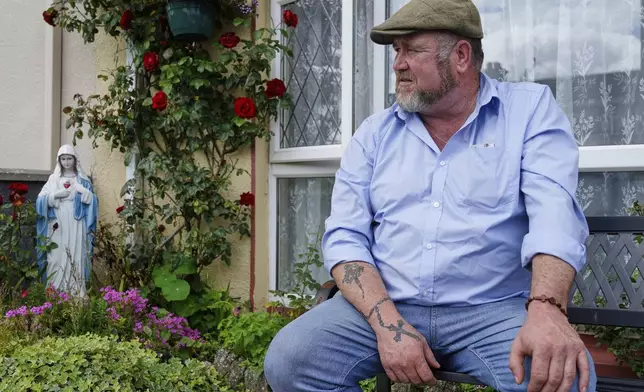 Patrick McDonagh, who grew up in the neighborhood built atop the former mother and baby home in Tuam, Ireland, sits outside his family's home on Tuesday, July 8, 2025. (AP Photo/Brian Melley)