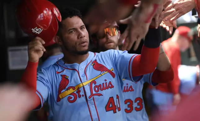 St. Louis Cardinals' Willson Contreras (40) and Brendon Donovan (33) celebrate with teammates in the dugout after both scoring on a Thomas Saggese 2-RBI single during the first inning of a baseball game against the Chicago Cubs Saturday, July 5, 2025, in Chicago. (AP Photo/Paul Beaty)