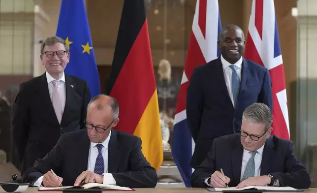 Britain's Prime Minister Keir Starmer, right, and German Chancellor Friedrich Merz, left, with Germany's Minister for Foreign Affairs Johann Wadephul, behind left, and Britain's Foreign Secretary David Lammy, behind right, as they attend a signing ceremony of a wide-ranging bilateral cooperation treaty in London, Thursday, July 17, 2025.(AP Photo/Frank Augstein, Pool)