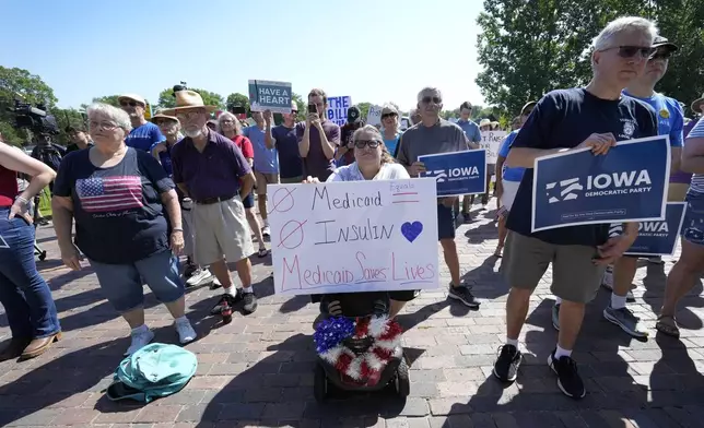 Local residents listen to a speech during an Iowa Democratic Party rally, Thursday, July 3, 2025, in Windsor Heights, Iowa. (AP Photo/Charlie Neibergall)