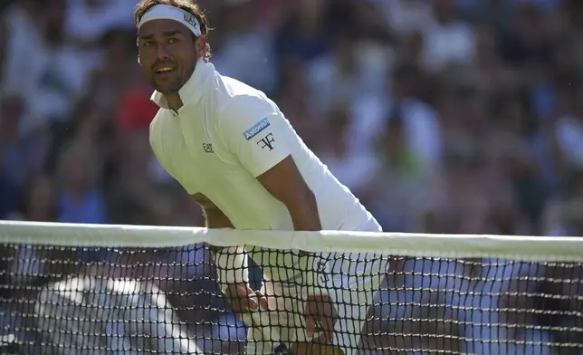 Fabio Fognini of Italy walks into the net and loses the point as he plays Carlos Alcaraz of Spain during their first round men's singles match at the Wimbledon Tennis Championships in London, Monday, June 30, 2025. (AP Photo/Alastair Grant)