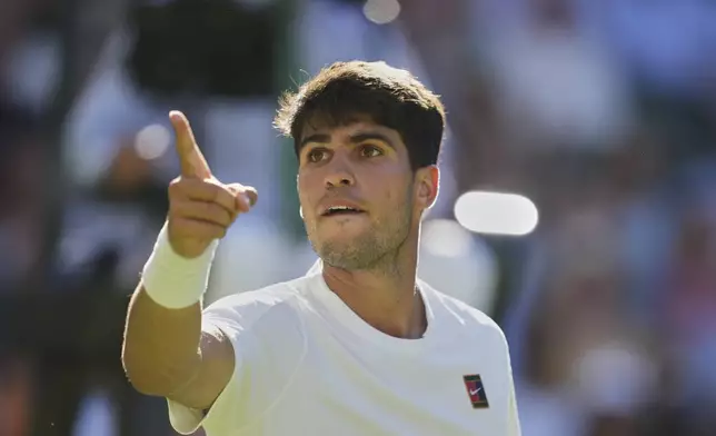 Carlos Alcaraz of Spain reacts after breaking the serve of Fabio Fognini of Italy during their first round men's singles match at the Wimbledon Tennis Championships in London, Monday, June 30, 2025. (AP Photo/Alastair Grant)