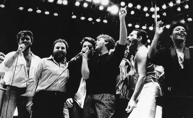 FILE - George Michael, from left, concert promoter Harvey Goldsmith, Bono, Paul McCartney, Bob Geldof, and Freddie Mercury appear during the London Live Aid Famine Relief Concert in London on July 13, 1985. (AP Photo/Joe Schaber, File)